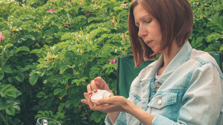 Woman in nature taking pills