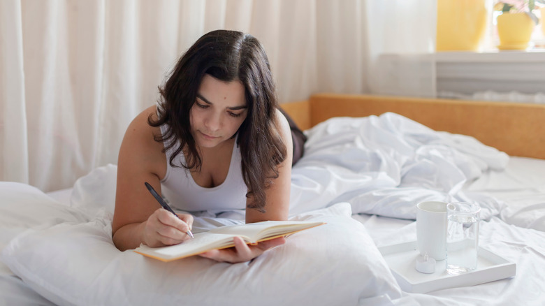 Woman writing in gratitude journal