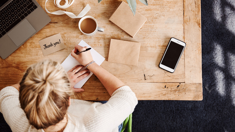 woman writing thank you card