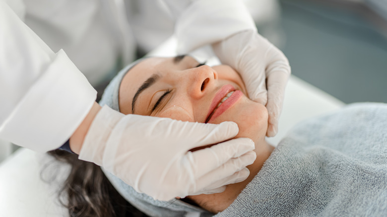 Woman smiling, getting skin treatment