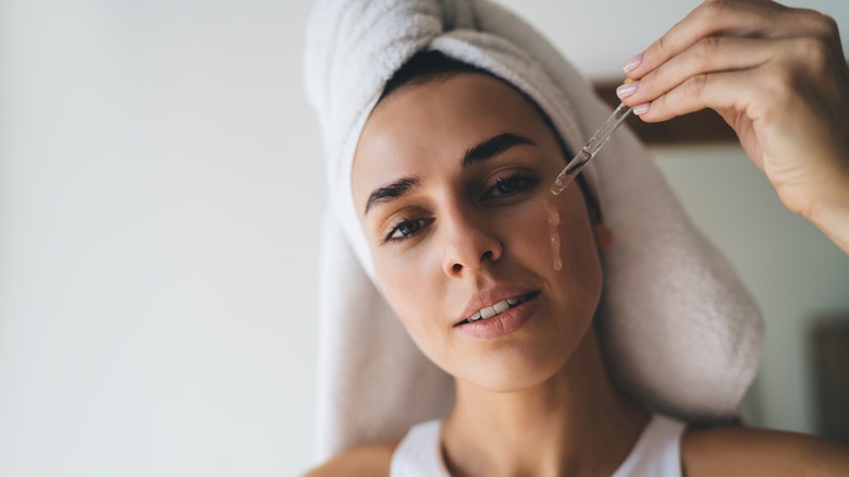 Woman applying face oil 