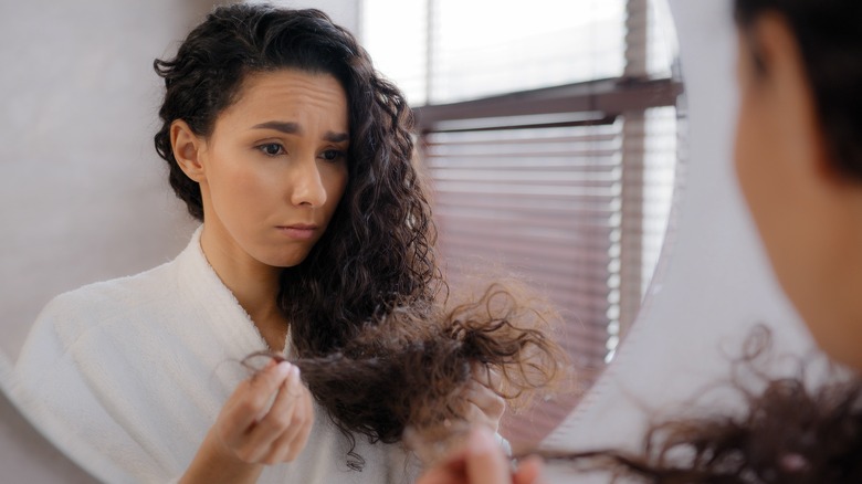 woman looking at damaged hair