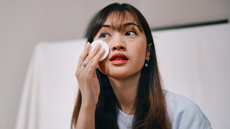woman removing face makeup