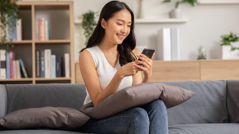 Woman smiles at phone screen