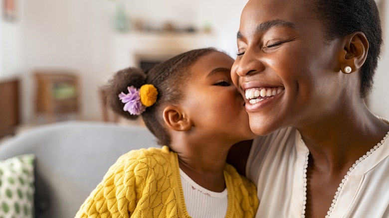 girl kisses mother on cheek