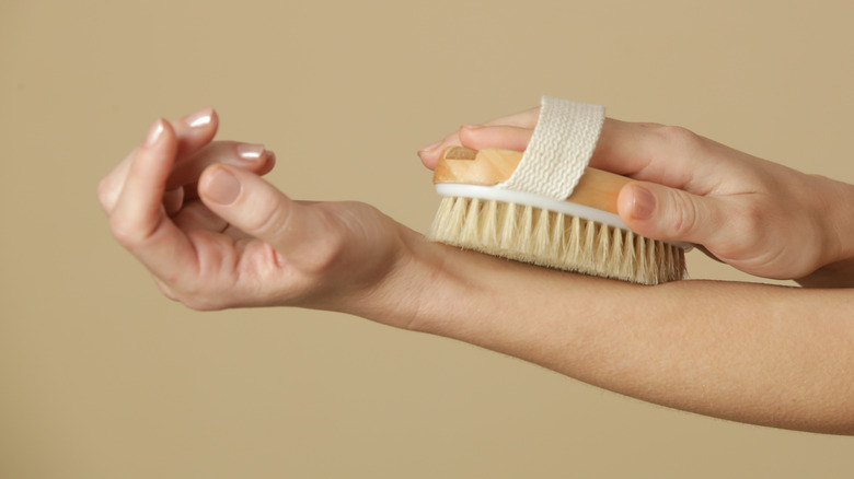 person dry brushing their arm