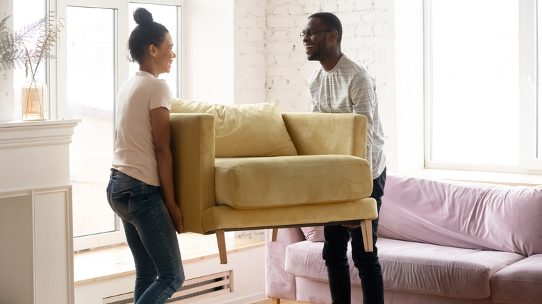 two people moving furniture