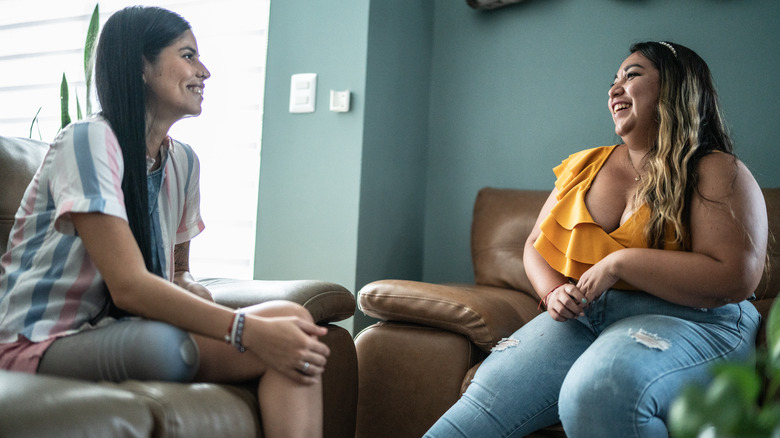 woman cheering up friend on couch