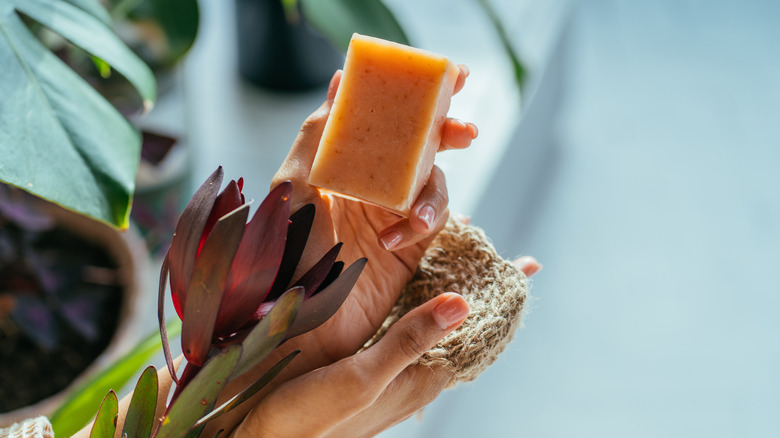 woman holding soap and flower