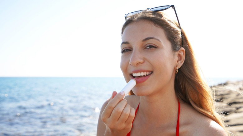 Woman applying lip product outside