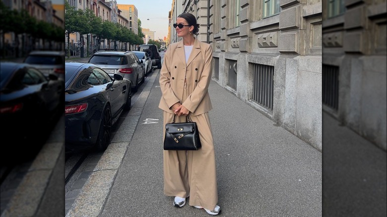 woman wearing oversized khaki pantsuit with sneakers