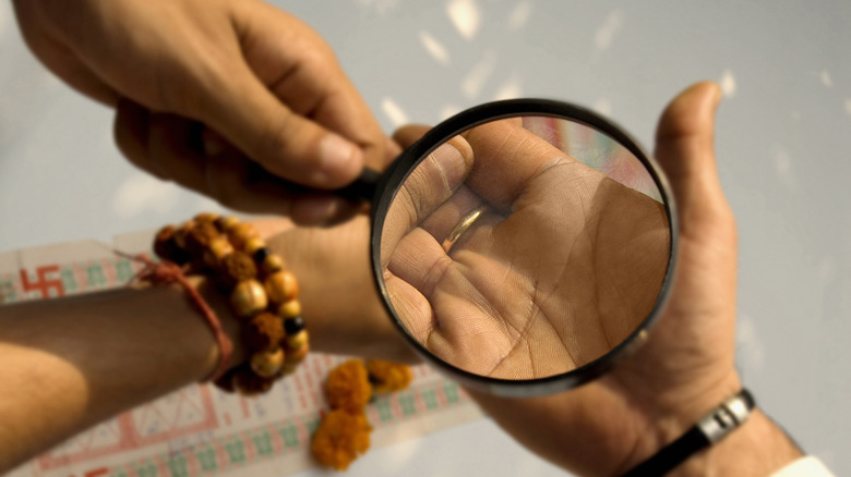 Magnifying glass held over palm