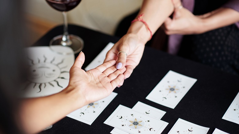 person holding palm cards on black table