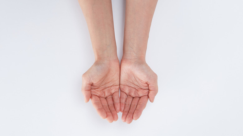 outstretched arms palms up white background