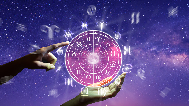 Hand holding a zodiac calendar