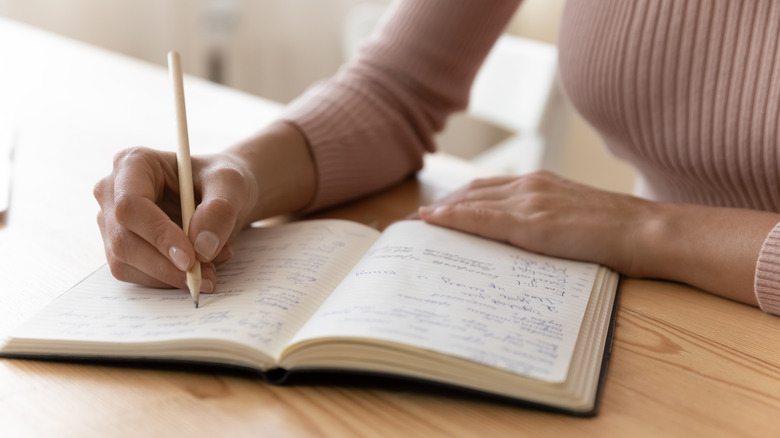 person writing in notebook