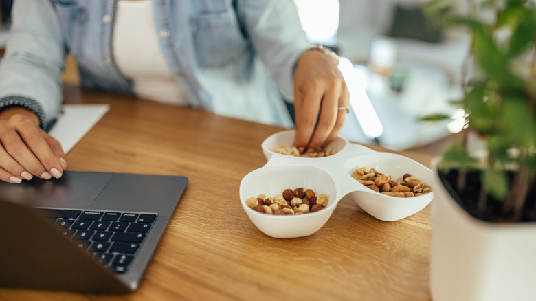 person eating nuts at desk