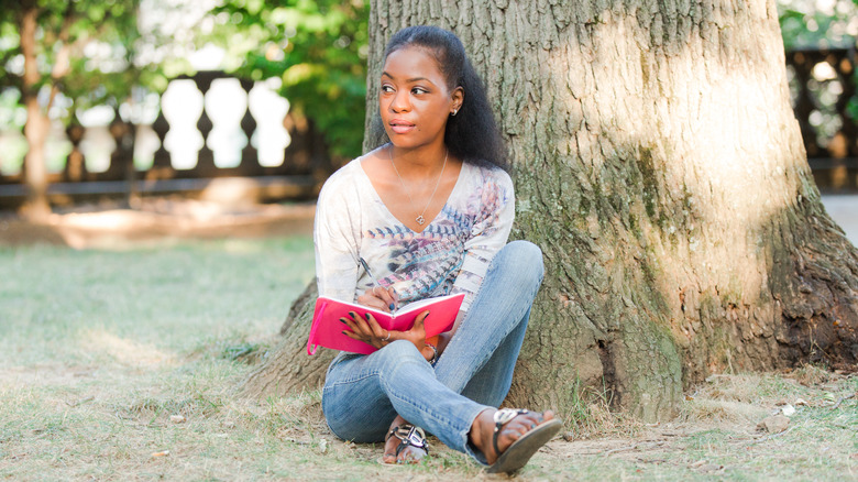 Woman sitting outside with notebook