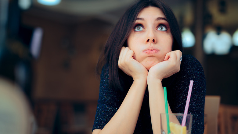 Woman with hands on chin