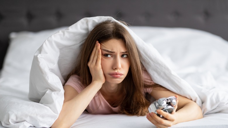 Scowling woman with alarm clock