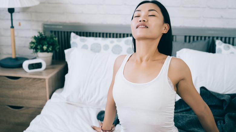 Woman gently stretching in bed