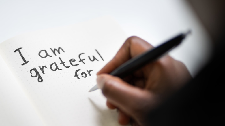 Woman writing in gratitude journal