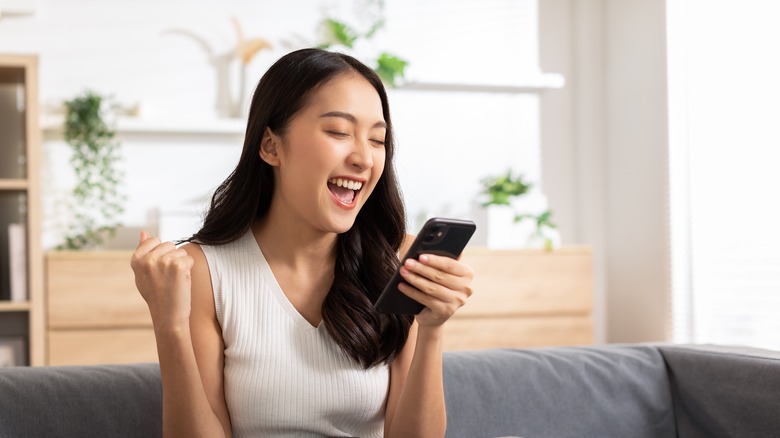 Woman holding smartphone laughing