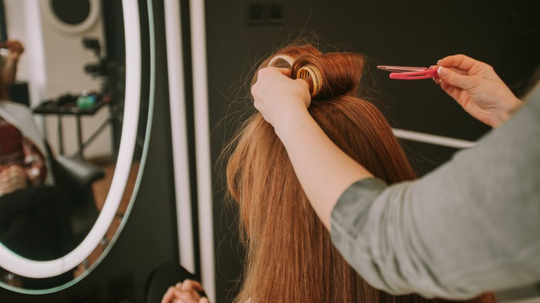 Woman getting hair rollers applied