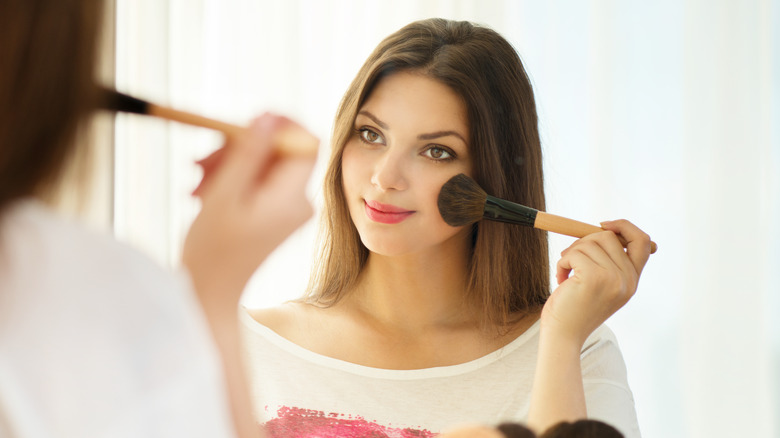 Woman applying blush