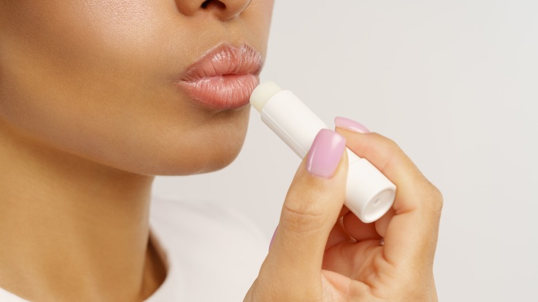 Woman applying lip balm