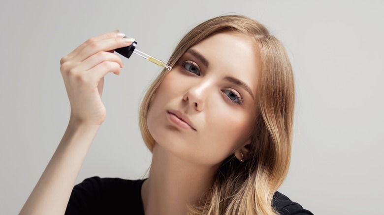 Woman applying facial oil
