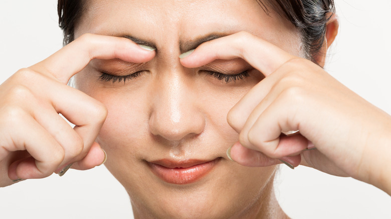 A woman massaging her eyebrows