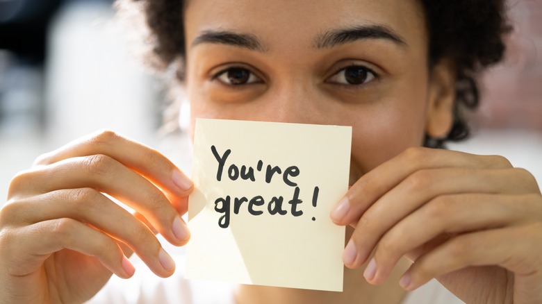 Person holding up affirmation note