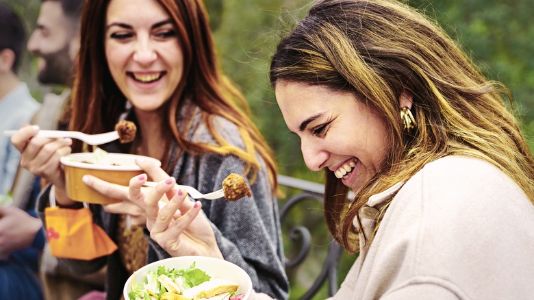 two happy women eating