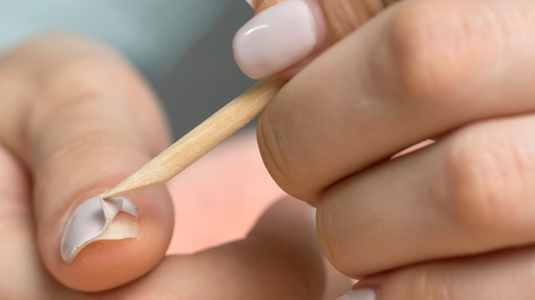 removing gel nails with a cuticle stick