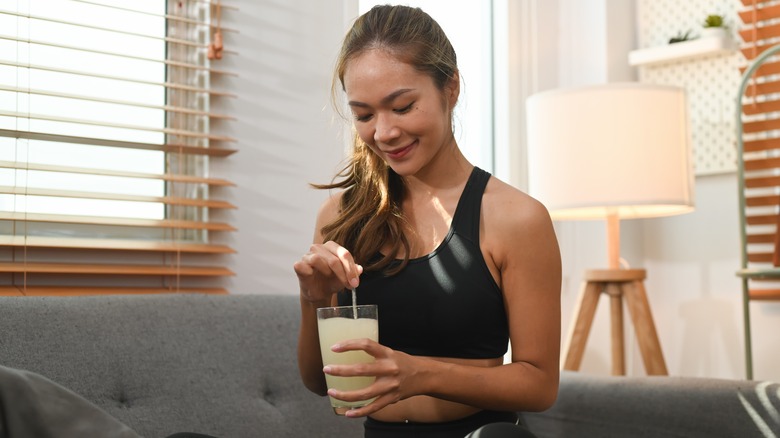 Woman taking a liquid collagen supplement