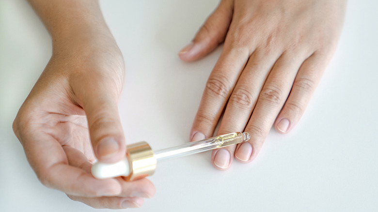 Woman using cuticle oil