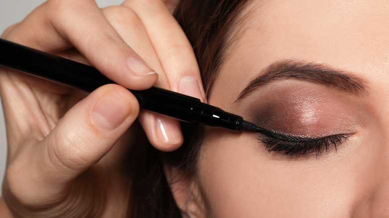 Woman doing eye makeup