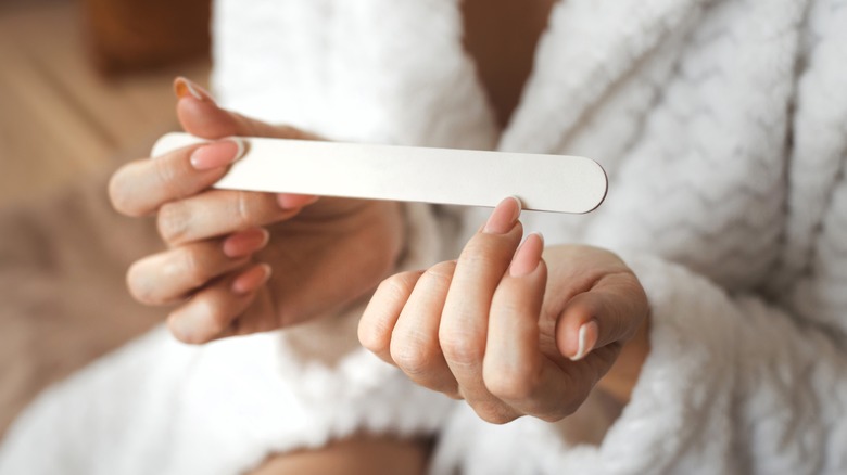 woman filing her nails