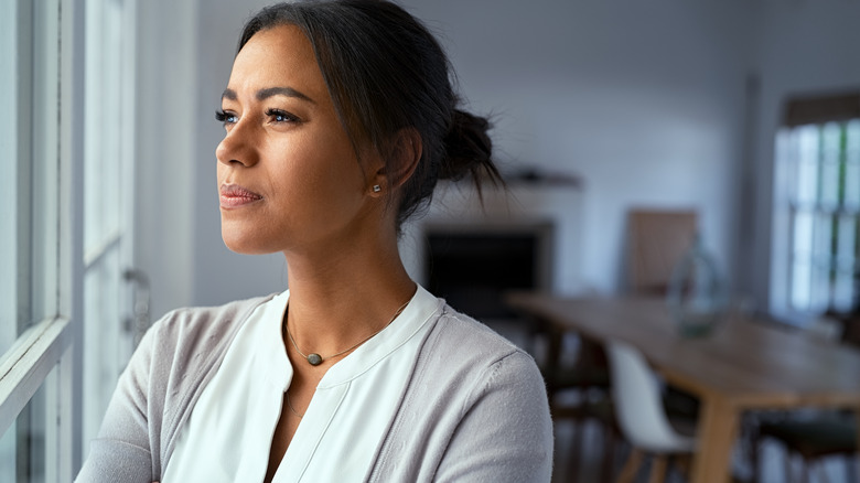 Woman contemplates while looking out window