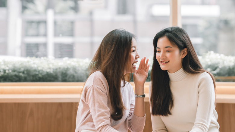 Two girls talking on sofa 