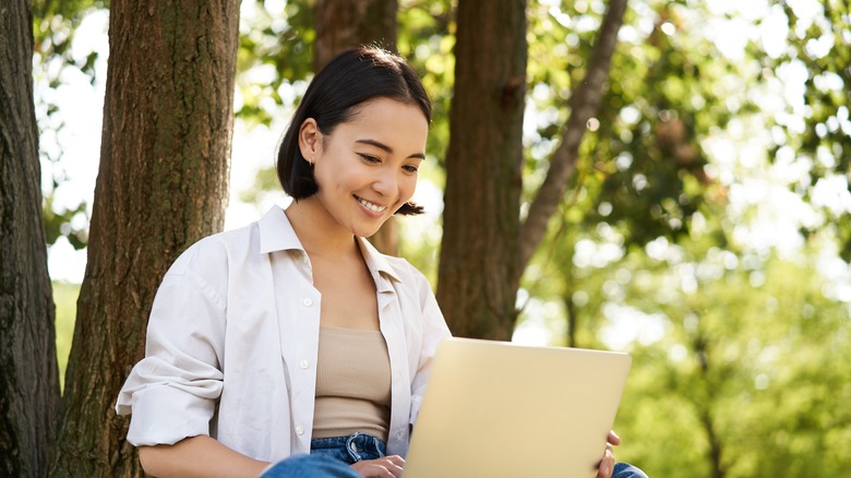 Woman in park with laptop