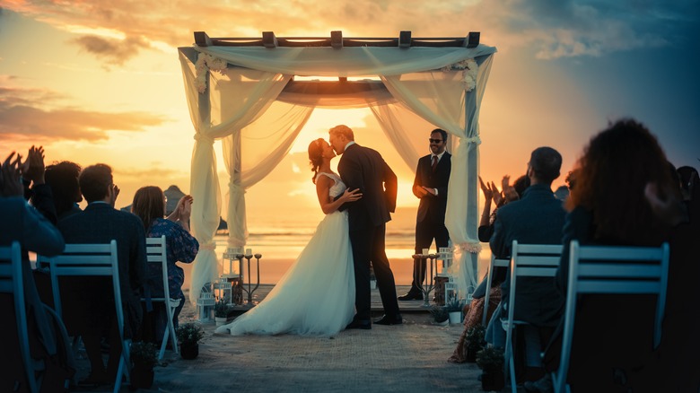 Couple getting married at sunset 
