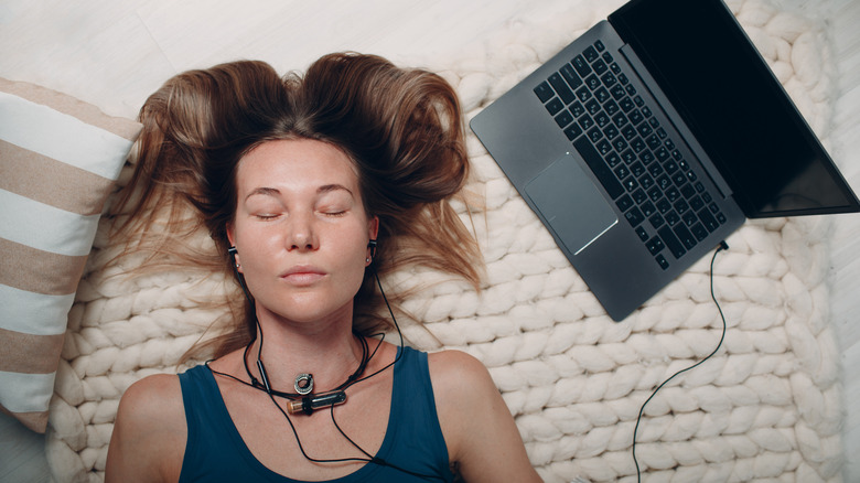 Woman listening to headphones while relaxing