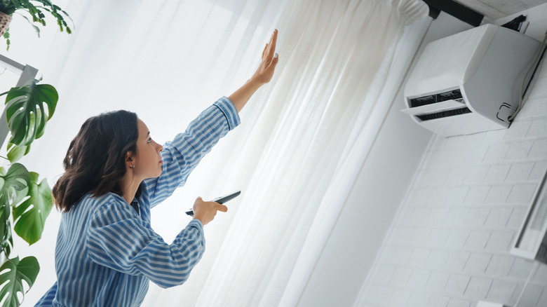 Woman feeling for air from AC