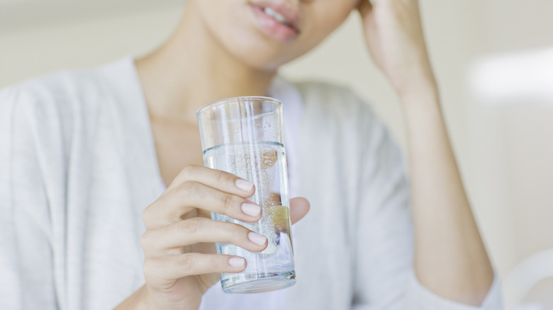 Woman holding glass of water