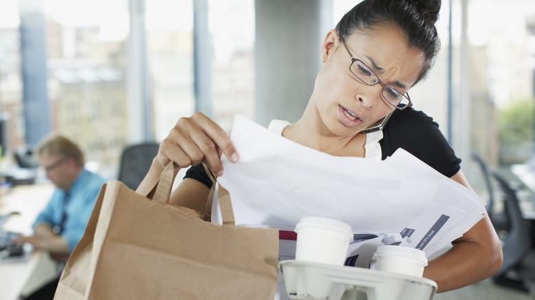 Woman busy multitasking, carrying multiple things and talking on the phone