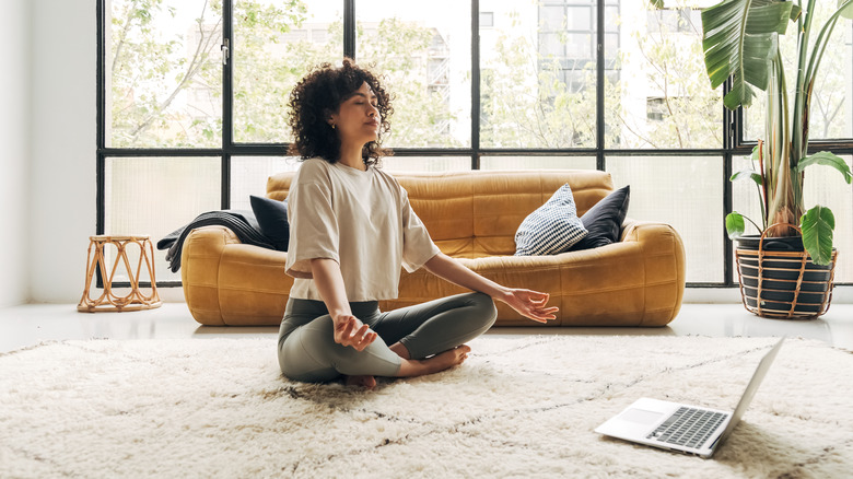 woman meditating in living room