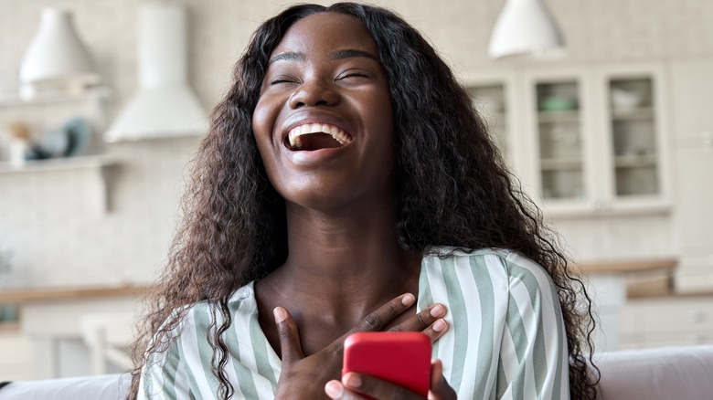 woman laughing with phone