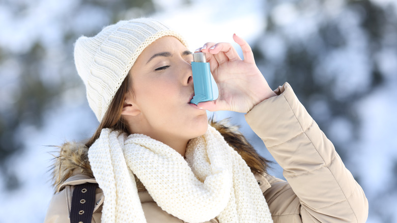 woman using inhaler in cold weather